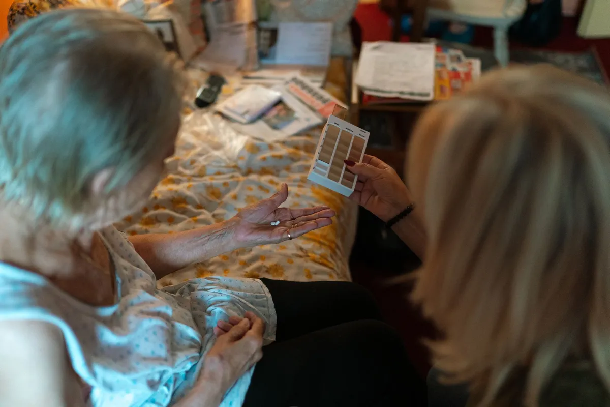 Caregiver showing color samples to a woman, fostering communication and engagement.